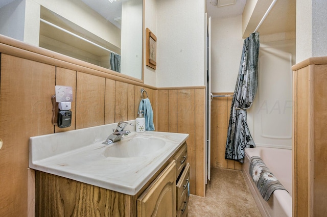 full bathroom with shower / bath combo, wainscoting, wooden walls, and vanity