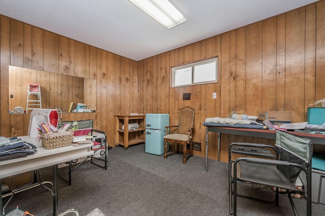 carpeted office space featuring wood walls and a textured ceiling