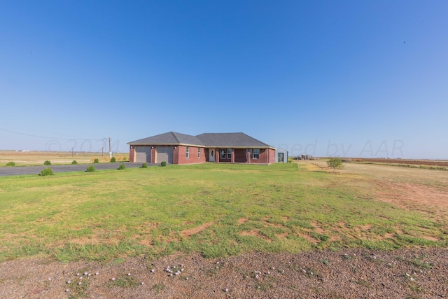 ranch-style home featuring a rural view and a front lawn