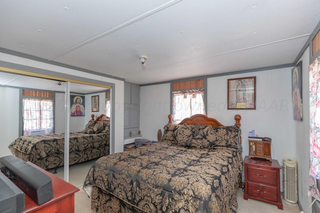 carpeted bedroom featuring multiple windows and a closet