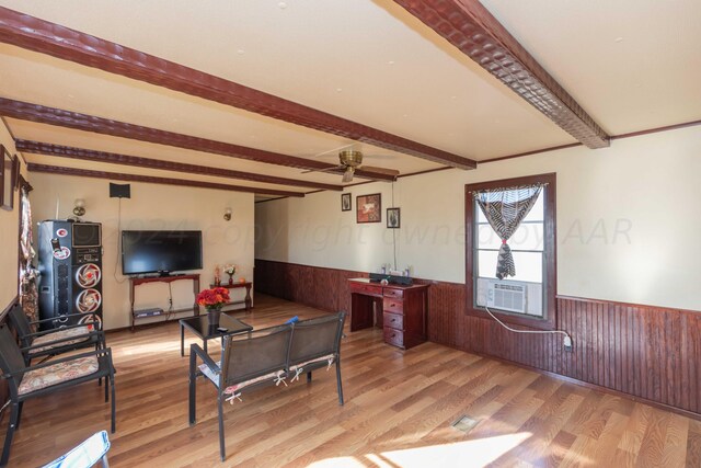 interior space with light wood-type flooring, cooling unit, ceiling fan, and beam ceiling