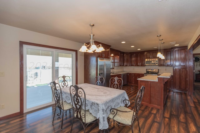 dining area with dark wood-type flooring, a chandelier, and sink