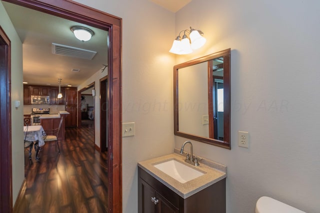 bathroom featuring hardwood / wood-style floors, vanity, and toilet