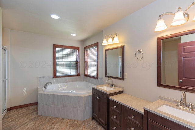 bathroom with vanity and tiled tub