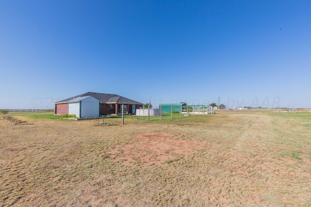 view of yard with an outdoor structure and a rural view