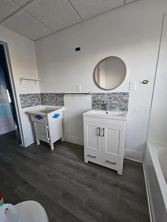 bathroom featuring vanity, hardwood / wood-style floors, and decorative backsplash