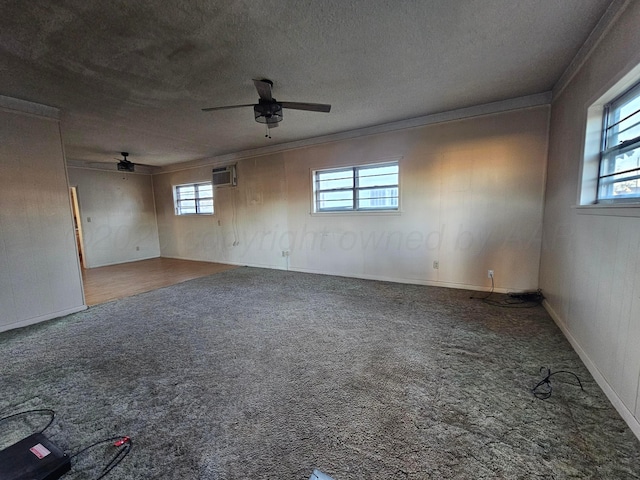 unfurnished room featuring carpet flooring, a wall unit AC, ceiling fan, crown molding, and a textured ceiling