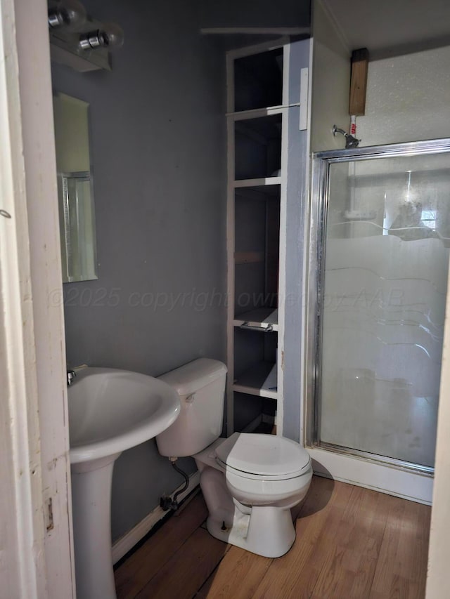 bathroom with hardwood / wood-style flooring, toilet, and an enclosed shower