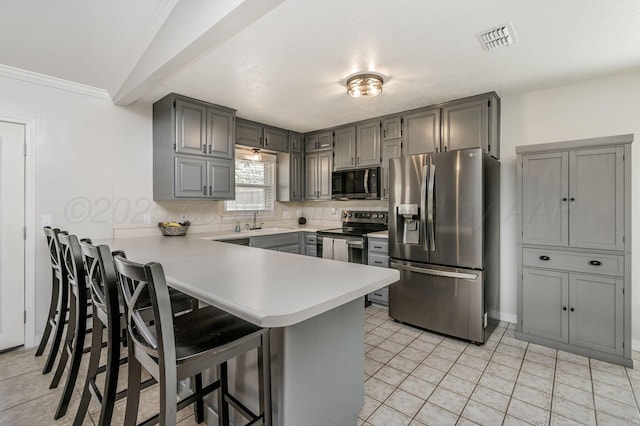 kitchen featuring kitchen peninsula, gray cabinetry, stainless steel appliances, sink, and light tile patterned floors