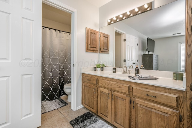 bathroom featuring tile patterned flooring, vanity, and toilet