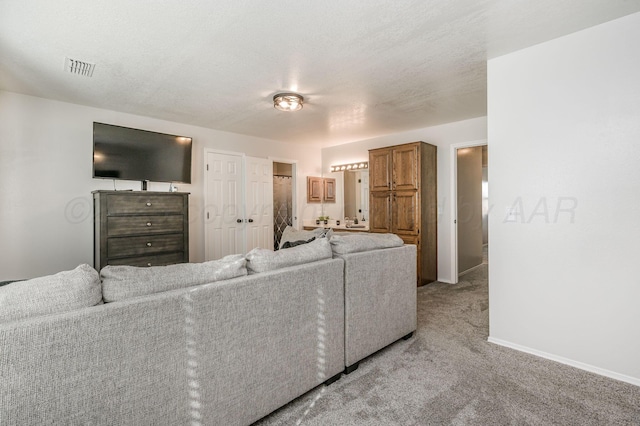 carpeted living room featuring a textured ceiling