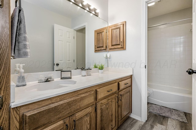 bathroom featuring hardwood / wood-style floors, tiled shower / bath combo, and vanity