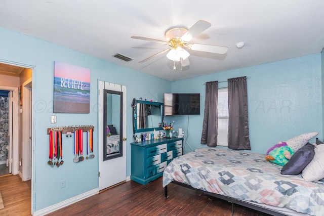 210 Oak Ave, Dumas, TX 79029 - bedroom with dark wood-style floors and a ceiling fan