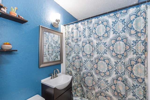 210 Oak Ave, Dumas, TX 79029 - bathroom with a textured wall, vanity, and a shower with shower curtain