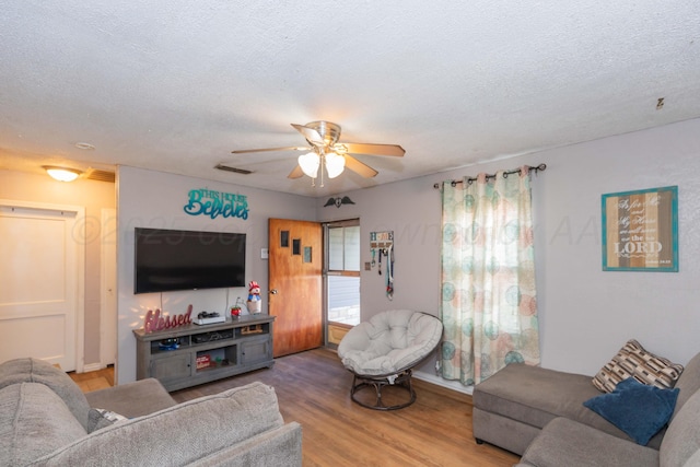 210 Oak Ave, Dumas, TX 79029 - living area featuring a ceiling fan, wood finished floors, and a textured ceiling