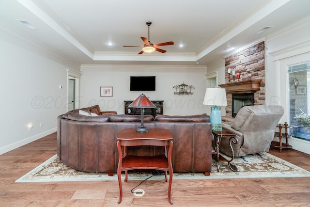 7601 Continental Pkwy, Amarillo, TX 79119 - living area featuring a stone fireplace, ceiling fan, a raised ceiling, wood finished floors, and ornamental molding