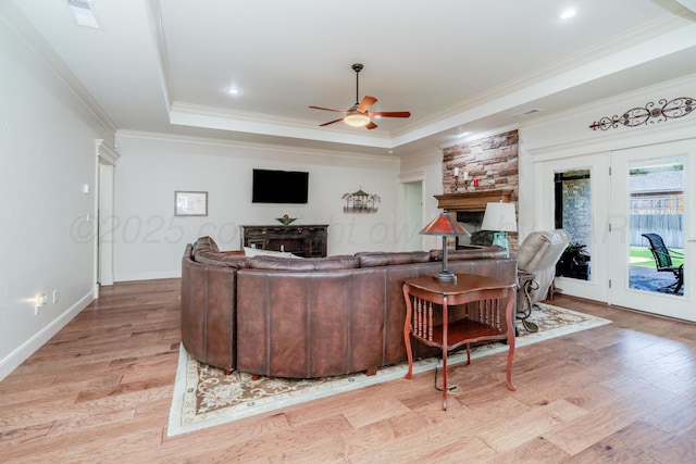7601 Continental Pkwy, Amarillo, TX 79119 - living area with a stone fireplace, ceiling fan, light wood-style flooring, a tray ceiling, and crown molding