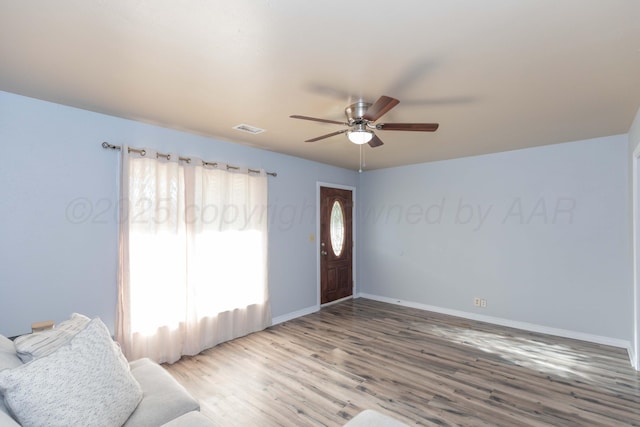 entrance foyer with wood finished floors, visible vents, a ceiling fan, and baseboards