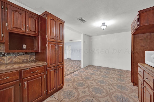 kitchen with light tile patterned floors and decorative backsplash