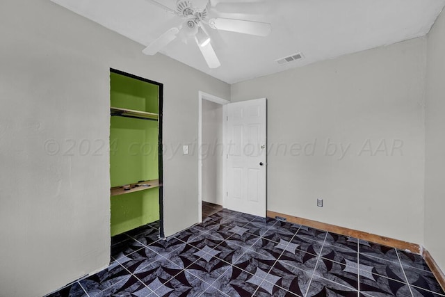 unfurnished bedroom with ceiling fan and a closet