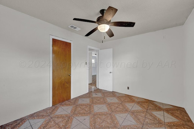 unfurnished bedroom featuring a textured ceiling and ceiling fan