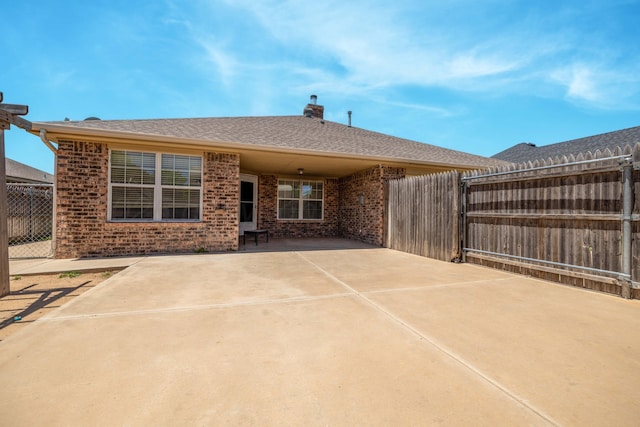 7703 Fresno Dr, Amarillo, TX 79118 - back of house featuring brick siding, fence, a chimney, and a patio area