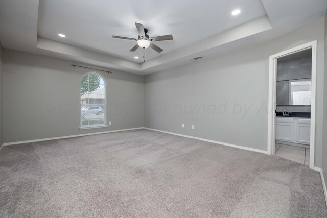 7703 Fresno Dr, Amarillo, TX 79118 - unfurnished bedroom with a raised ceiling, light colored carpet, baseboards, recessed lighting, and a sink