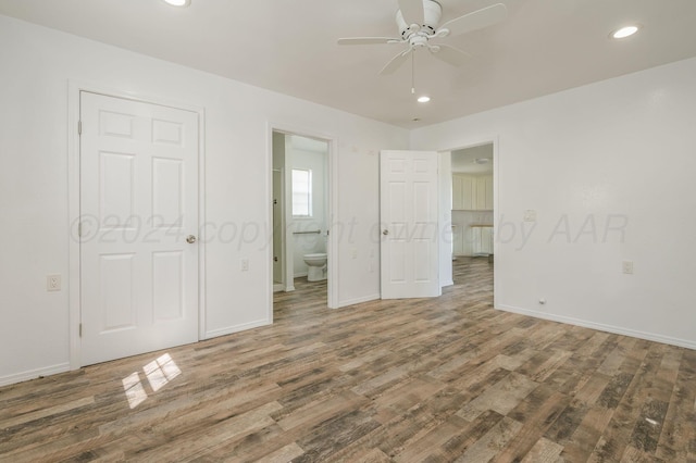 unfurnished bedroom featuring ensuite bathroom, ceiling fan, and dark hardwood / wood-style floors