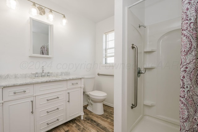 bathroom featuring curtained shower, toilet, vanity, and hardwood / wood-style flooring