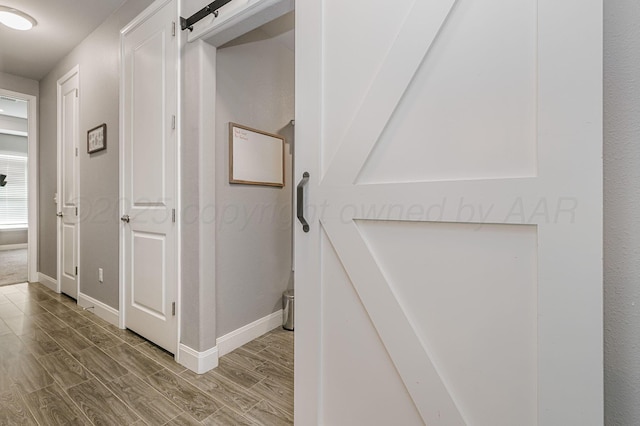 corridor featuring hardwood / wood-style flooring and a barn door