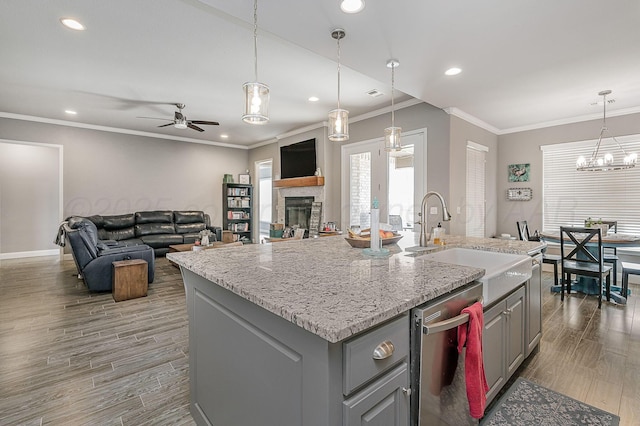 kitchen with dishwasher, sink, gray cabinetry, and a center island with sink