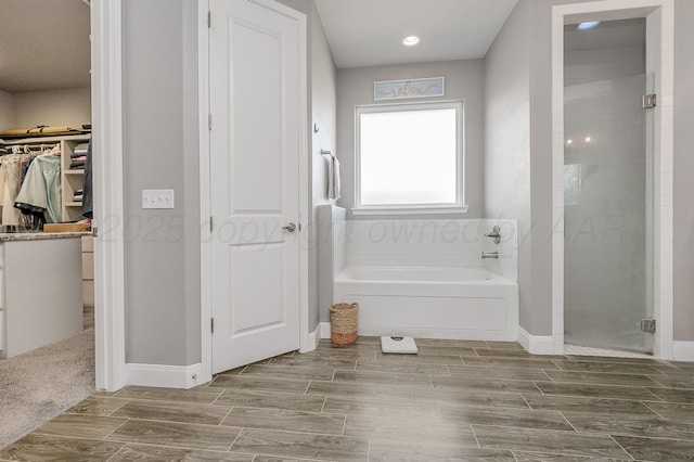 bathroom featuring shower with separate bathtub