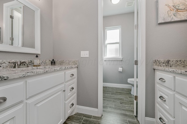 bathroom featuring vanity, hardwood / wood-style flooring, and toilet