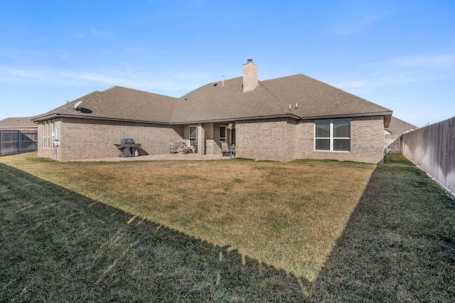 rear view of property featuring a lawn and a patio