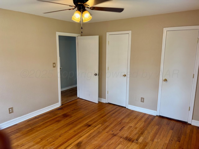 unfurnished bedroom featuring baseboards, ceiling fan, and wood finished floors