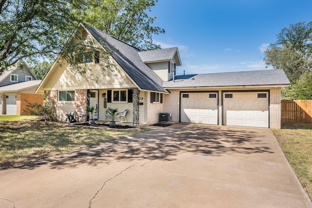 view of front of home with fence, an attached garage, driveway, and brick siding