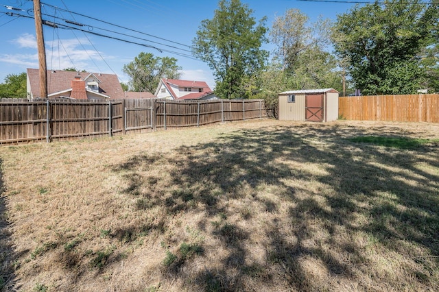 view of yard featuring an outbuilding, a storage shed, and a fenced backyard