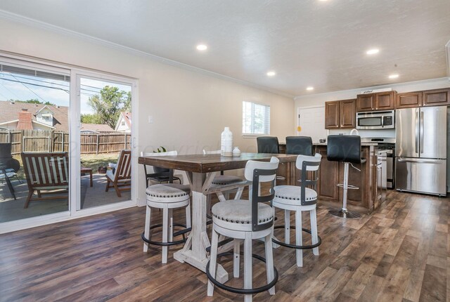 dining space featuring crown molding, recessed lighting, and dark wood-type flooring