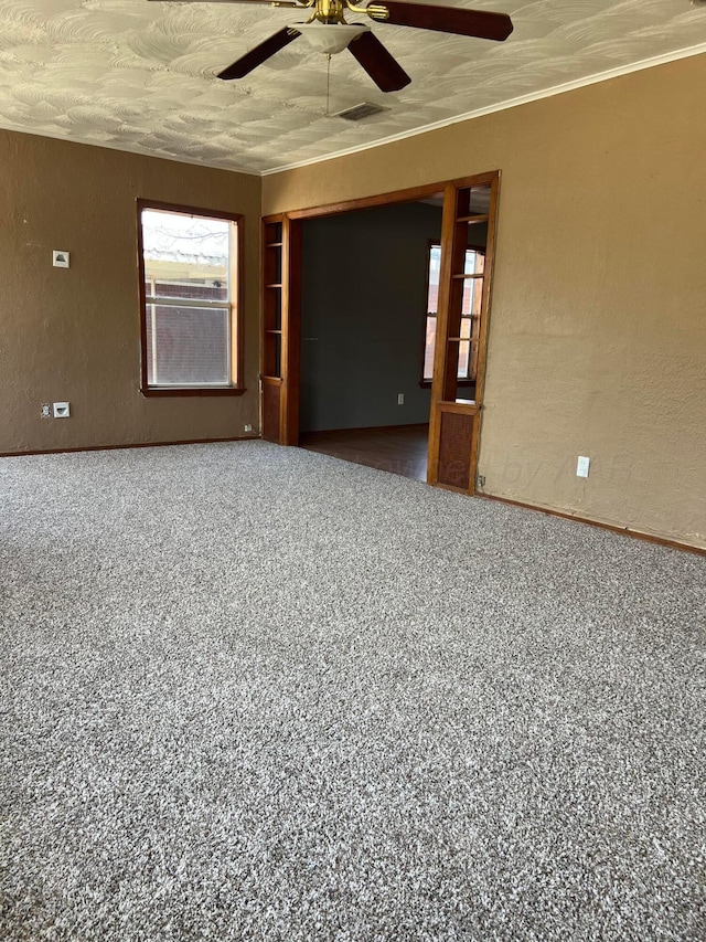 unfurnished room featuring a textured ceiling, visible vents, ornamental molding, a ceiling fan, and a textured wall
