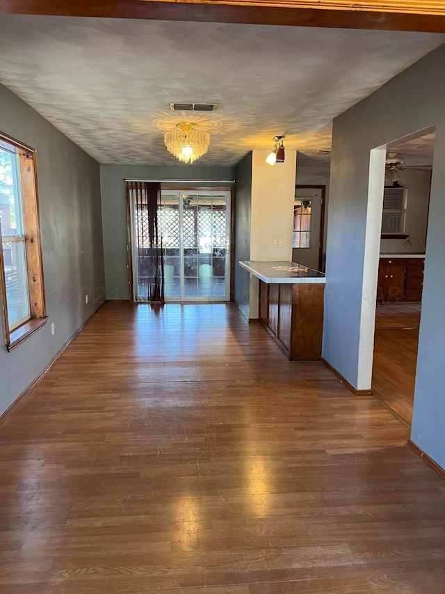 unfurnished dining area with wood-type flooring and an inviting chandelier