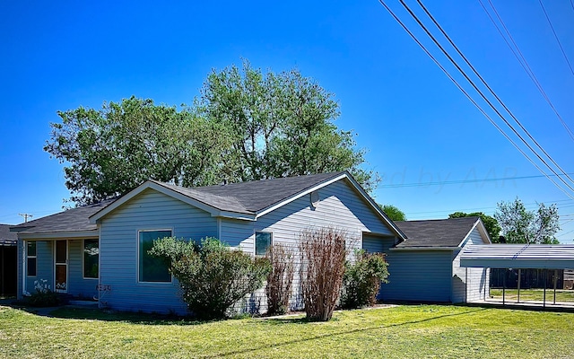 view of home's exterior with a carport and a yard