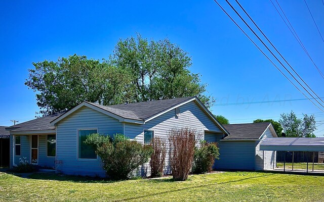 715 Ave Q, Sunray, TX 79086 - view of front of house featuring a front lawn, roof with shingles, and a carport