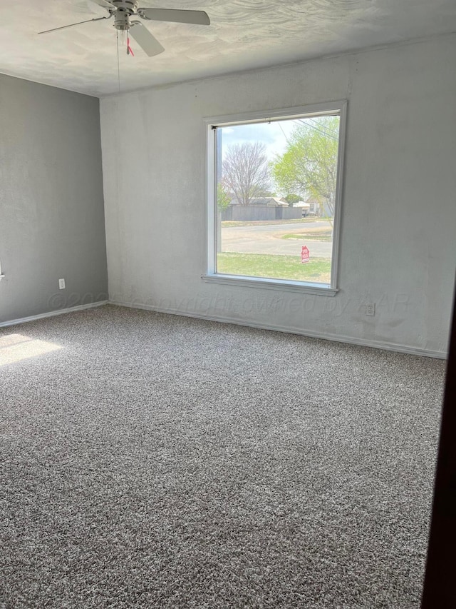 unfurnished room featuring baseboards and ceiling fan