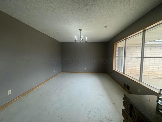 unfurnished room featuring baseboards, visible vents, a textured ceiling, concrete floors, and a notable chandelier