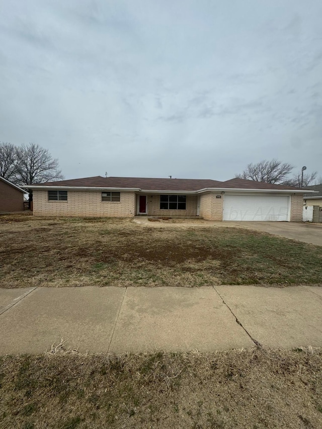 single story home with concrete driveway and an attached garage