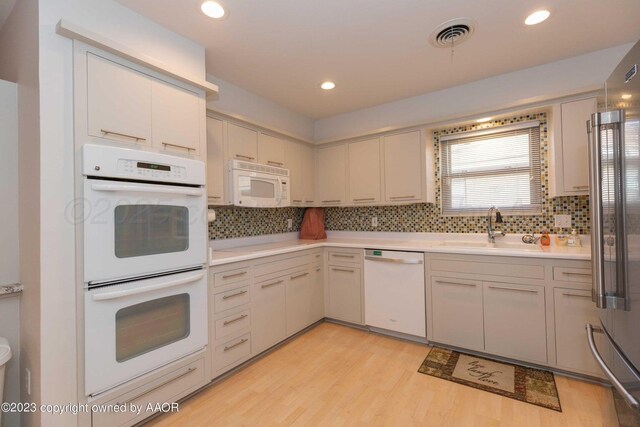6810 Montague Dr, Amarillo, TX 79109 - kitchen featuring white appliances, light countertops, light wood-style floors, backsplash, and recessed lighting