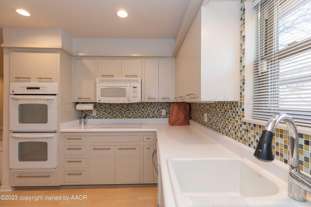 6810 Montague Dr, Amarillo, TX 79109 - kitchen with white appliances, light countertops, backsplash, recessed lighting, and light wood-type flooring