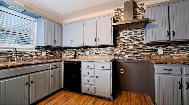 kitchen featuring black dishwasher, gray cabinets, and wall chimney exhaust hood