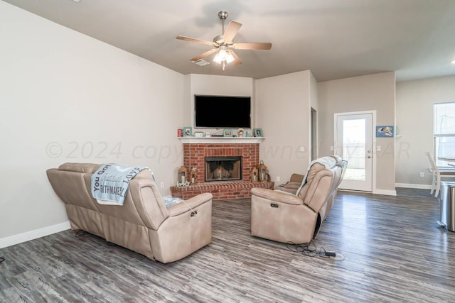 living room with a brick fireplace, hardwood / wood-style floors, and ceiling fan