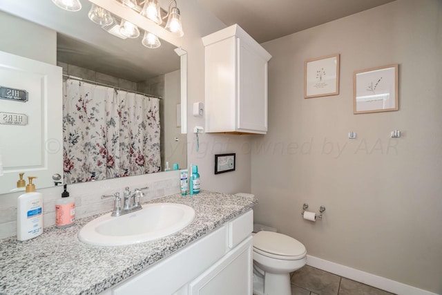 bathroom with toilet, vanity, and tile patterned flooring